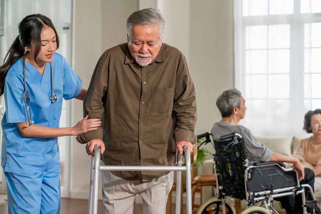 Caregiver calmly assists an older adult during a meal in a bright, well-maintained residence.