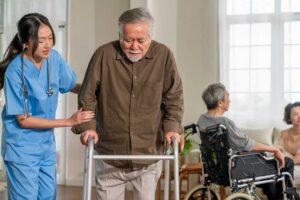 Caregiver calmly assists an older adult during a meal in a bright, well-maintained residence.